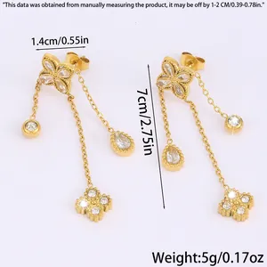 Detailed view of long gold tassel earrings with clover design and crystal measurements