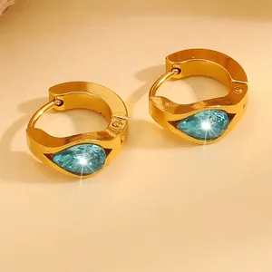 Macro shot of gold-plated huggie earrings with pear-cut aquamarine zircon stones