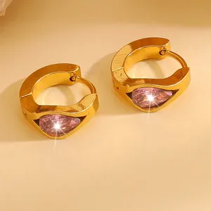 Detail of gold-plated hoop earrings featuring a pear-cut pink zircon with a starburst glow