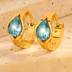 Detailed shot of gold plated hoop earrings with pear cut light blue zircon stones