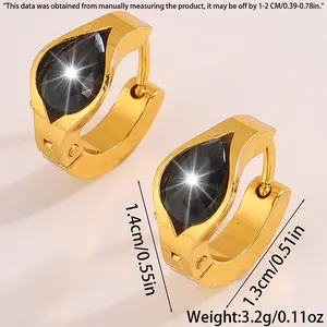 Macro detail of gold-plated chunky huggie hoops featuring black pear-cut zircon inlay