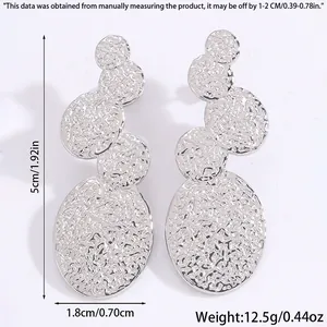 Boucles d'oreilles argentées avec disques métalliques texturés empilés et dimensions