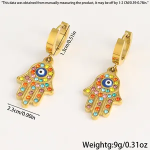 Detailansicht der Hamsa-Hand-Ohrringe mit blauem Auge und Maßen auf weißem Hintergrund