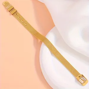 Détail du bracelet en maille milanaise dorée avec boucle réglable et texture fine en acier