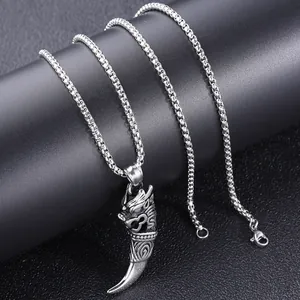 Detailed shot of retro silver dragon head pendant with vintage carved texture on black stand