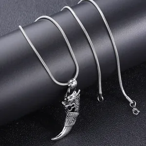 Detail of vintage silver dragon fang pendant on a snake bone chain for men
