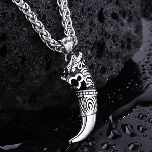 Close-up of retro dragon tooth pendant with textured scales on black volcanic rock