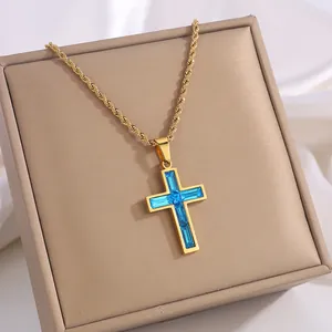 Detailaufnahme der goldenen Edelstahl-Kreuzkette mit blauen Zirkonia in einer Schmuckbox