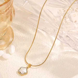 Gros plan sur un collier chaîne serpent dorée avec pendentif fleur en turquoise et strass