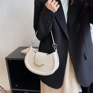 Minimalist creamy white crescent shoulder bag with elegant golden hardware and smooth finish