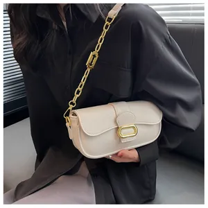 Detalle de bolso baguette de cuero beige con textura de lichi y hebilla de metal dorado