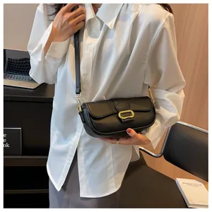 Detalle de bolso bandolera de cuero granulado negro con elegante hebilla oval dorada