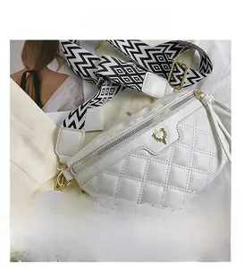 Detailed close-up of white quilted crossbody bag with golden deer buckle and patterned strap