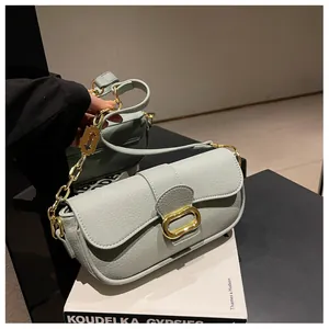 Bolso bandolera de piel granulada verde claro con herrajes dorados y colgante
