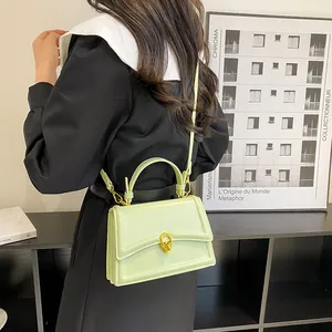 Detail van de pistachegroene lederen tas met gouden ringsluiting op een model
