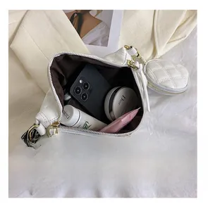 Detail view of white quilted shoulder bag showing interior capacity for phone and cosmetics