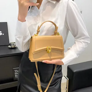 Detail van de elegante kameelkleurige PU-handtas met een goudkleurige draaisluiting