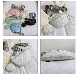 Detail view of quilted crossbody bag with gold deer buckle and geometric wide strap