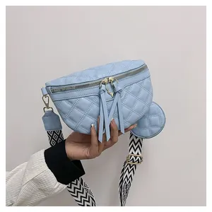 Detail of light blue quilted waist bag with gold deer hardware and patterned strap