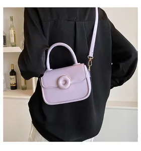 Chic lilac crossbody bag featuring a round decorative buckle and adjustable shoulder strap