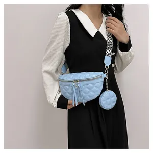Detail of light blue quilted crossbody bag with a round coin purse and woven strap