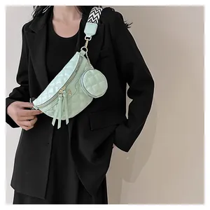 Detail of mint green quilted waist bag with round pendant and geometric shoulder strap