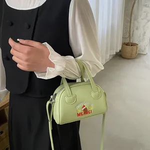 Detail of pistachio green leather bag with festive Christmas embroidery and top handle