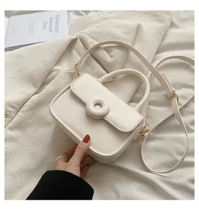 Minimalist cream white PU leather crossbody handbag with gold hardware on soft fabric