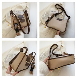 Detailopnames van de beige en bruine color-block crossbody tas met konijnenhanger