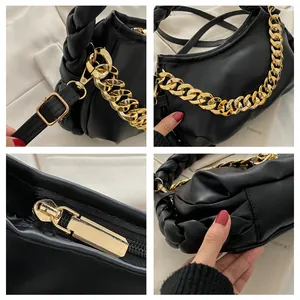 Detail view of black pleated cloud bag with golden chain and woven handle textures
