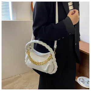 Detail of white pleated cloud bag featuring gold chain and woven handle in high quality