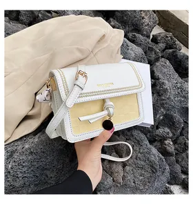 Dettaglio borsa a tracolla in pelle bianca con inserto intrecciato, foulard e logo oro