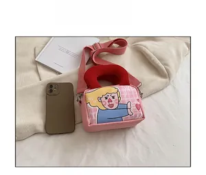 Detailed view of pink canvas crossbody bag with cartoon illustration and red handles