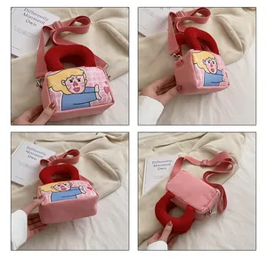 Detail view of pink canvas crossbody bag with cartoon girl print and red top handles