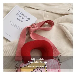 Detail view of the pink canvas crossbody bag showing the adjustable wide fabric shoulder strap
