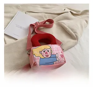 Detail of pink canvas bag with red handles, cartoon illustration, and adjustable strap