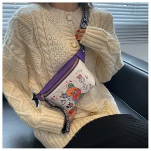 Detalle de bolso bandolera con grafiti de oso colorido y correa ancha con letras blancas