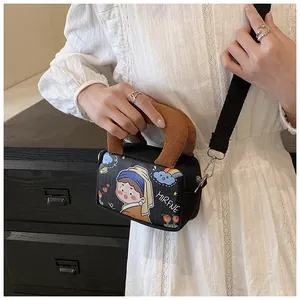 Detail of canvas crossbody bag with cartoon art print and brown corduroy handles