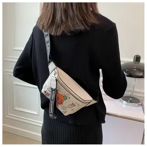 Detalle de bolso bandolera crema con grafiti de colores y correa negra de marca
