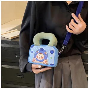 Close-up of a blue mini canvas bag featuring a cute cartoon cat and green corduroy handle