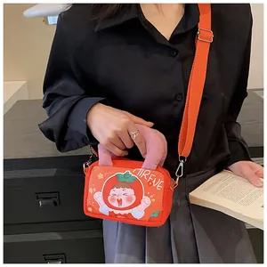 Close-up of orange canvas handbag with cartoon illustration and pink handle straps