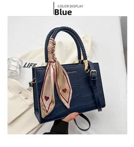 Deep blue faux crocodile leather handbag with woven handles and a red heart silk scarf