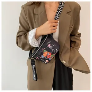 Detalle de bolso bandolera negro con grafiti de oso y correa tejida de marca