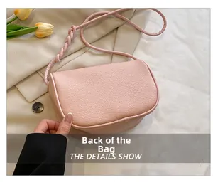 Rear view of a light pink lychee texture shoulder bag with stylish twisted strap details