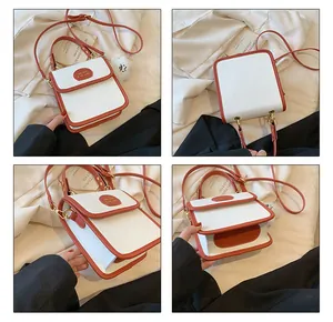 Vista dettagliata di una borsa quadrata in pelle bianca con bordo arancione e ciondolo