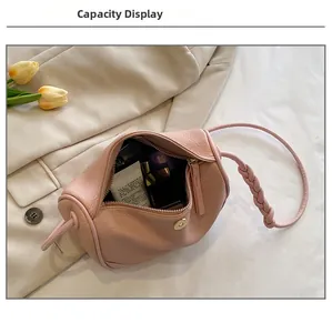 Spacious interior of a pink textured leather barrel bag showing storage capacity