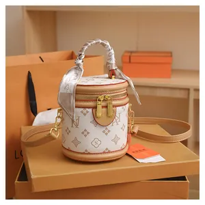 Detailed view of a white and brown monogram bucket bag on a premium orange gift box
