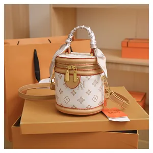 Detail of white monogram bucket bag with silk scarf handle and gold-tone hardware