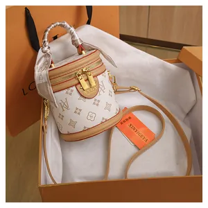 Detailed view of luxury bucket bag with monogram pattern in an orange gift box setup