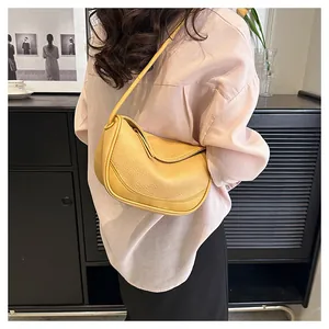 Lifestyle view of mustard yellow textured leather shoulder bag on a female model